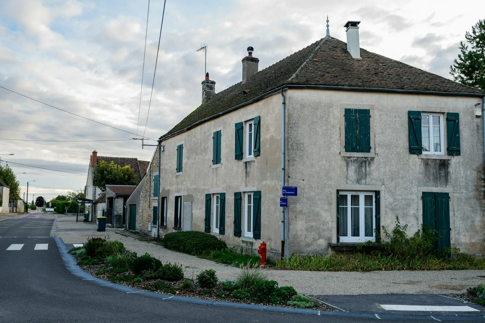 Maison de village française aux volets verts, en bord de rue