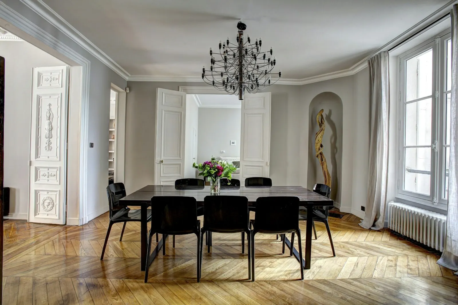 Salle à manger d’un appartement parisien avec parquet et moulures
